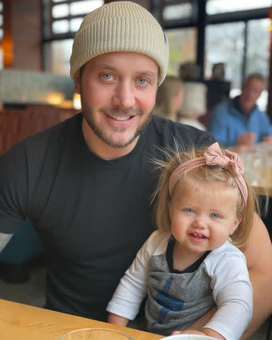 <p>Mina Starsiak Hawk Instagram</p> Steve Hawk holds his daughter Charlotte Drew Hawk while at a restaurant.