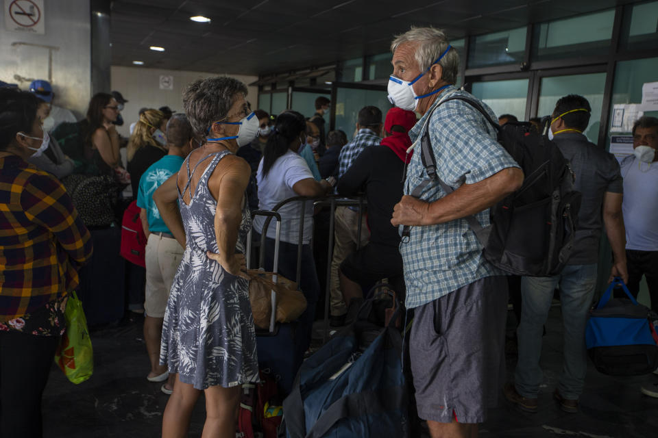 Travelers wait for a charter flight coordinated by the U.S. embassy at the La Aurora airport in Guatemala City, Tuesday, March 24, 2020. American citizens stranded abroad because of the coronavirus pandemic are seeking help in returning to the United States. (AP Photo/Moises Castillo)
