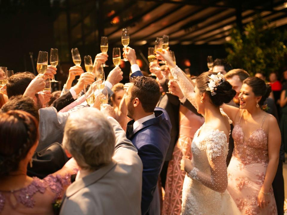 Bride, groom and wedding guests making a toast (Getty Images)