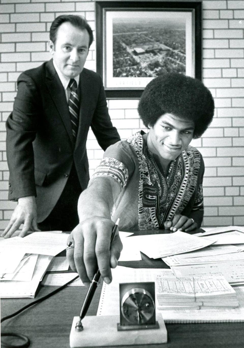 Kent State University football head coach Don James joins Garfield High School's Larry Poole on signing day in March of 1971.