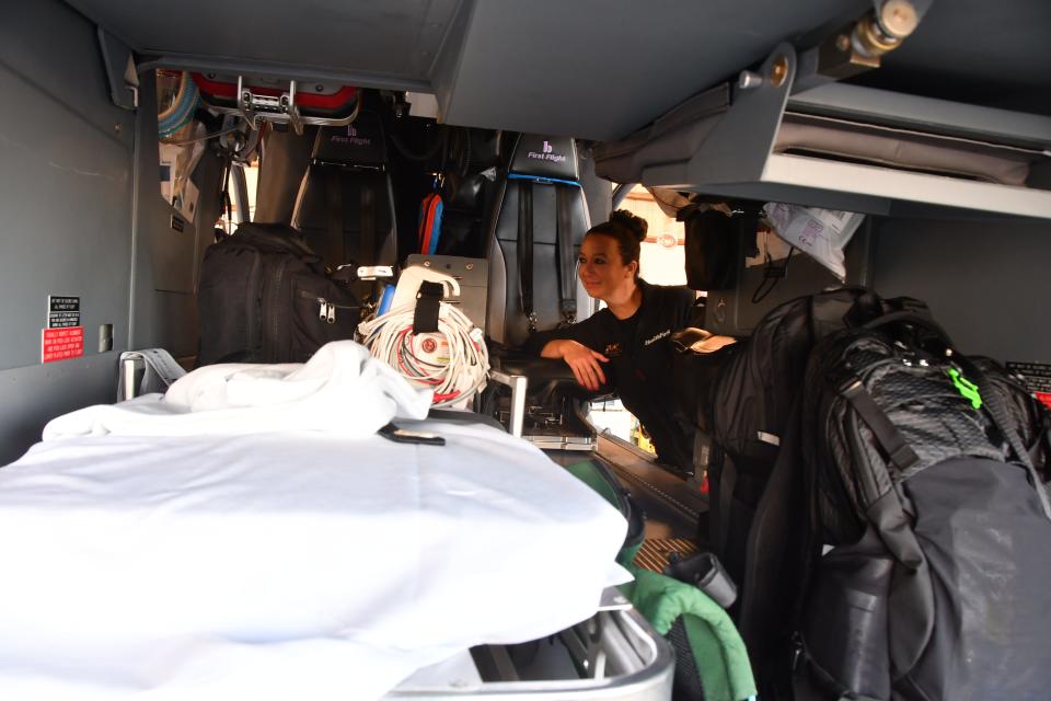 First Flight paramedic April Inganna peers inside the helicopter toward the white stretcher where patients lay during flights.