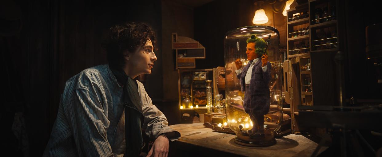 Willy Wonka (Timothée Chalamet, left) catches an intruding Oompa Loompa (Hugh Grant) in "Wonka."