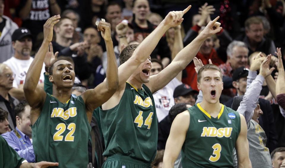 Players on the North Dakota State bench stand and cheer as their team takes the lead against Oklahoma in overtime during a second-round game of the NCAA men's college basketball tournament in Spokane, Wash., Thursday, March 20, 2014. North Dakota State won 80-75 in overtime. (AP Photo/Elaine Thompson)