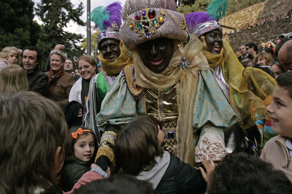 Hombre disfrazado del rey Baltasar junto con sus pajes. (REUTERS/Jon Nazca)