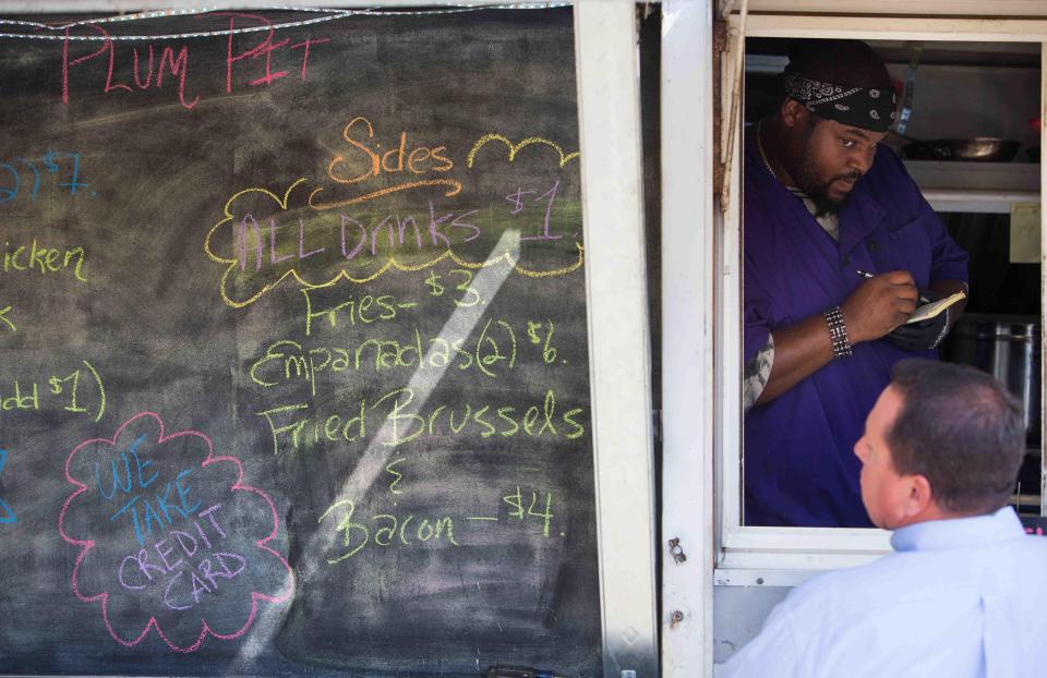 Kahlil Floyd of the Plum Pit food truck serves customers in 2015 at The Delaware Contemporary in Wilmington.