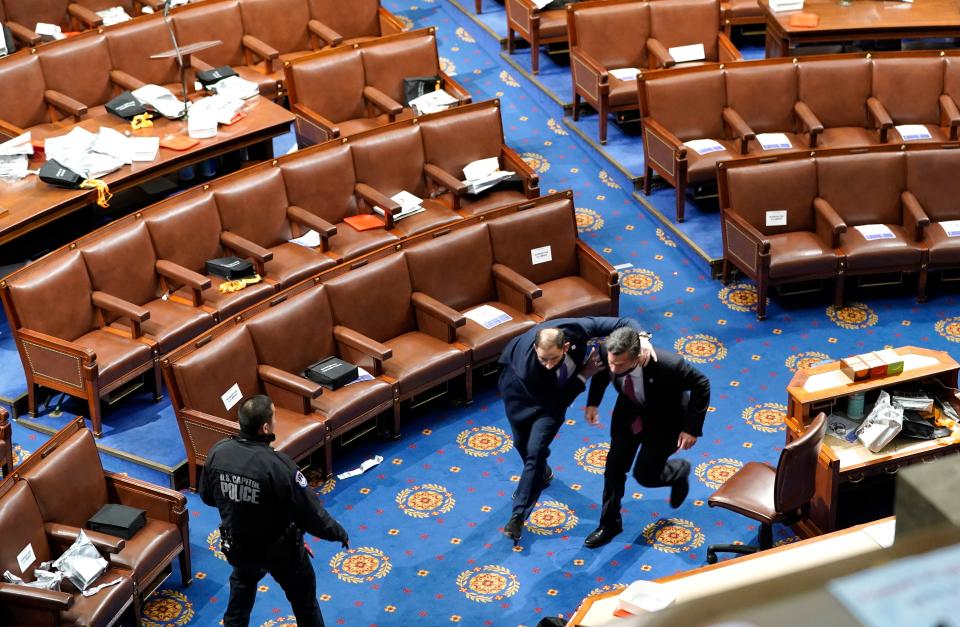 Members of congress run for cover as protesters try to break into the House Chamber, January 06, 2021.