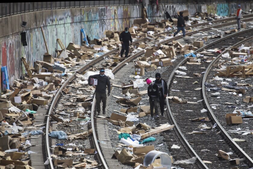 Los Angeles, CA - January 15: People rummaging through stuff stolen from cargo containers littered on Union Pacific train tracks in the vicinity of Mission Blvd. on Saturday, Jan. 15, 2022 in Los Angeles, CA. (Irfan Khan / Irfan Khan)