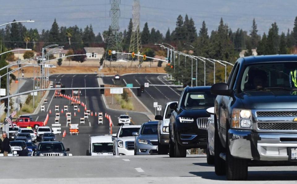 A parade of cars begin driving over Veterarans Boulevard after the opening ribbon-cutting ceremony Monday, Nov. 20, 2023 in Fresno.