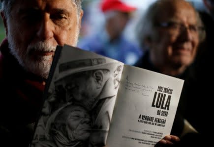 Brazil's former Foreign Minister Celso Amorim show a message of Pope Francis written on a book on Brazil's former President Luiz Inacio Lula da Silva after visiting him at the he Federal Police headquarters in Curitiba, Brazil August 16, 2018.  REUTERS/Rodolfo Buhrer