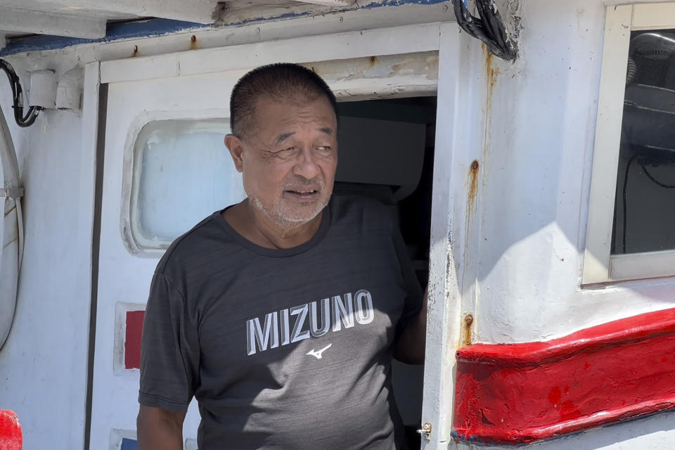 Fishing boat owner Chou Ting-tai, looks out from his boat at the Badouzi fishing port in Keelung, Taiwan Thursday, Aug. 4, 2022. China says it conducted "precision missile strikes" in the Taiwan Strait on Thursday as part of military exercises that have raised tensions in the region to their highest level in decades. (AP Photo/Johnson Lai)