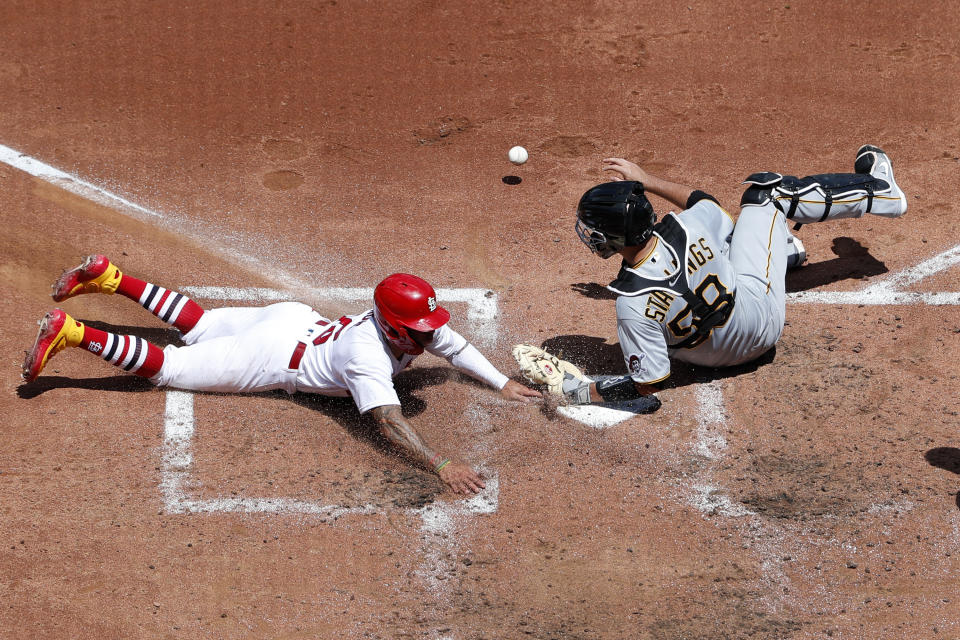 St. Louis Cardinals' Kolten Wong, left, scores as Pittsburgh Pirates catcher Jacob Stallings drops the ball during the third inning of a baseball game Sunday, July 26, 2020, in St. Louis. (AP Photo/Jeff Roberson)