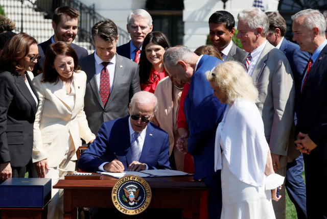U.S. President Joe Biden signs the CHIPS and Science Act of 2022 alongside Vice President Kamala Harris, House of Representatives Speaker Nancy Pelosi and Commerce Secretary Gina Raimondo on the South Lawn of the White House in Washington, U.S., August 9, 2022. REUTERS/Evelyn Hockstein