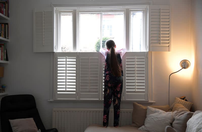 Eve,9, looks out of the front window at home in London