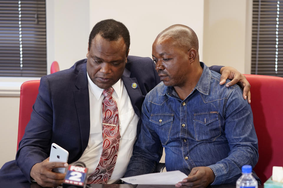 Kent County Commissioner Robert Womack shows Peter Lyoya the broadcast feed in attorney Ven Johnson's office, Thursday, June 9, 2022, in Detroit. A Michigan police officer who killed Peter's son, Patrick Lyoya, with a shot to the back of the Black man's head has been charged with second-degree murder. Prosecutor Chris Becker announced the charges Thursday against Grand Rapids Officer Christopher Schurr, weeks after Lyoya was killed following a chaotic traffic stop on April 4. (AP Photo/Carlos Osorio)