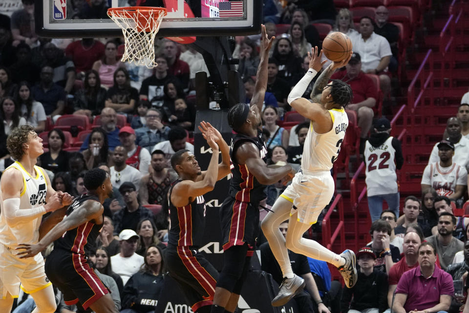 Utah Jazz guard Keyonte George (3) goes to the basket as Miami Heat center Orlando Robinson, third from left, and forward Jimmy Butler, second from right, defend during the first half of an NBA basketball game, Saturday, March 2, 2024, in Miami. (AP Photo/Lynne Sladky)