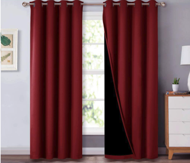 Heavy burgundy grommet curtains hanging from a silver rod