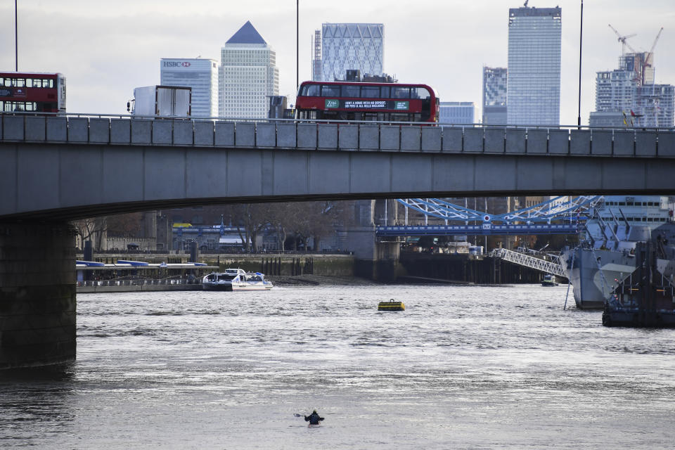 Buses and cars remain on London Bridge in London, Sunday Dec. 1, 2019, after it being closed to traffic and public after an attack on Friday. Authorities in Britain say the convicted terrorist who stabbed to death two people and wounded three others in a knife attack Friday had been let out of prison in an automatic release program. (AP Photo/Alberto Pezzali)