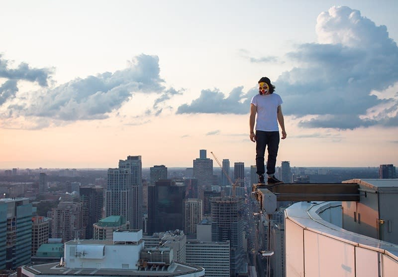 Photographer Tom Ryaboi standing high above the Toronto skyline <b>Photo - Tom Ryaboi</b>