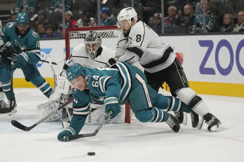 San Jose Sharks center Mikael Granlund (64) reaches for the puck in front of Los Angeles Kings defenseman Drew Doughty (8) during the first period of an NHL hockey game in San Jose, Calif., Tuesday, Dec. 19, 2023. (AP Photo/Jeff Chiu)