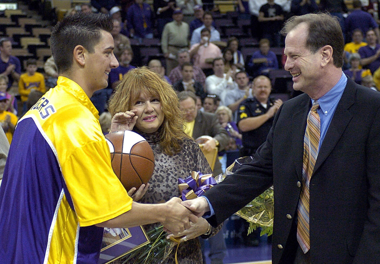 FILE - LSU senior Josh Maravich, left, shakes hands with coach John Brady as his mother, Jackie Maravich, center, watches during Senior Day events before LSU's NCAA college basketball game against Vanderbilt on March 5, 2005, at the Pete Maravich Assembly Center in Baton Rouge, La. Maravich, son of Pete Maravich, has died at age 42, the university announced Saturday, June 8, 2024. Josh Maravich was found unresponsive at home Friday, the LSU statement said. (AP Photo/Bill Feig, File)