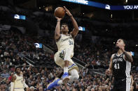 Milwaukee Bucks forward Giannis Antetokounmpo (34) shoots past San Antonio Spurs forward Trey Lyles (41) during the second half of an NBA basketball game in San Antonio, Monday, Jan. 6, 2020. (AP Photo/Eric Gay)