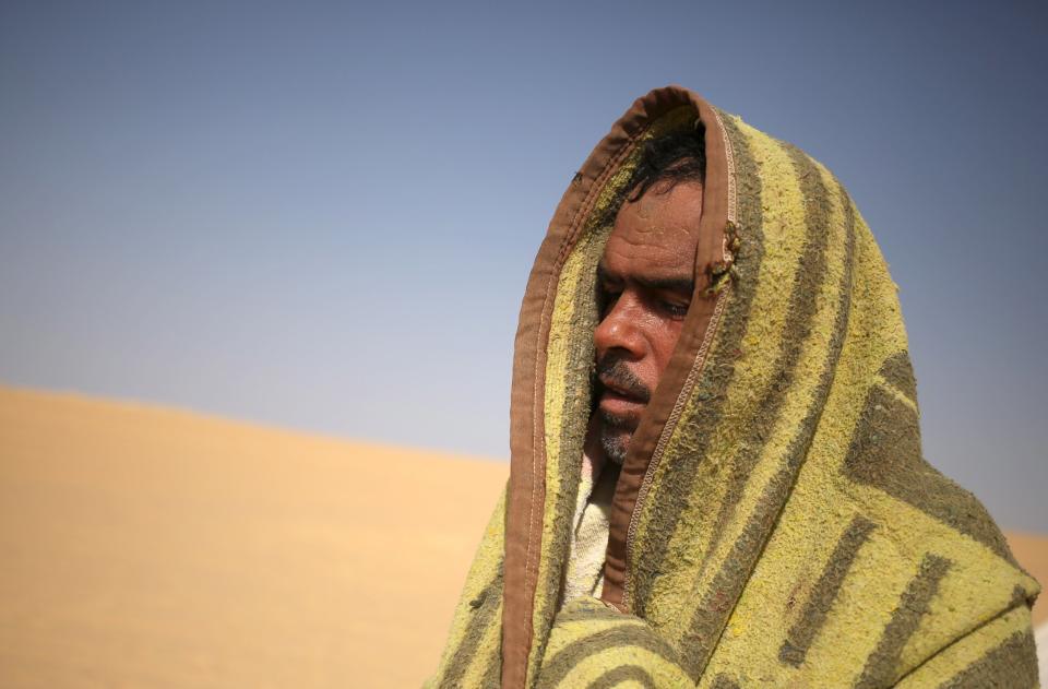 A patient, who is wrapped in a blanket, leaves a "sauna" tent after his sand bath in Siwa, Egypt, August 13, 2015. (REUTERS/Asmaa Waguih)