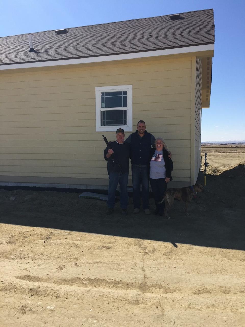 Wiggins Constructions marketing director Matt Thomas (middle) poses with Stan and Debbie LaBlue, who received an AR-15 rifle from the company Wednesday morning. The LaBlue's moved to Wyoming from California.