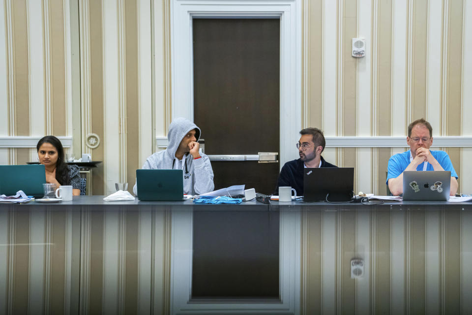 Former Scripps National Spelling Bee winners Kavya Shivashankar, from left, George Thampy, Sameer Mishra, and Pronouncer Jacques Bailly attend a word panel meeting to finalize the 2023 Scripps National Spelling Bee words on Sunday, May 28, 2023, at National Harbor in Oxon Hill, Md. (AP Photo/Nathan Howard)