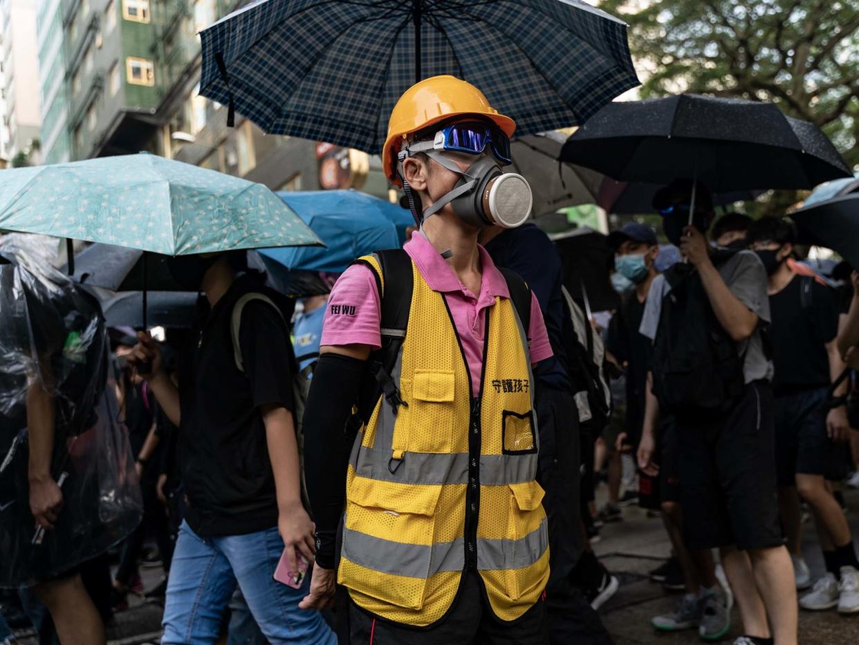 Pro-democracy volunteer stands in front of Tsim Sha Tsui Police Station as protesters march on a street on October 12, 2019 in Hong Kong: Getty