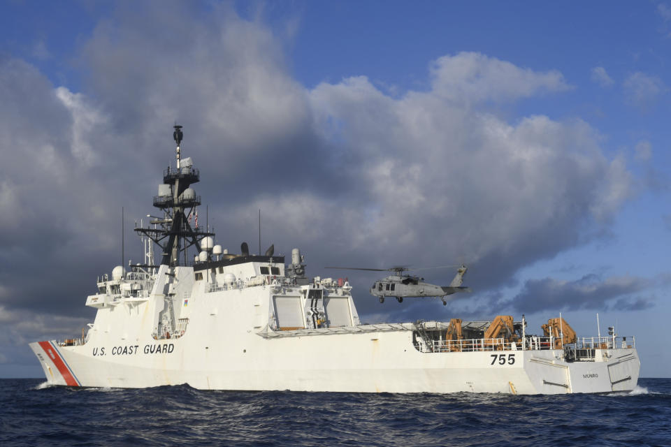 In this Aug. 25, 2020 photo provided by the U.S. Navy, an MH-60S Sea Hawk Helicopter hovers next to the the Legend-class cutter USCGC Munro in the Pacific Ocean. The Coast Guard cutter Munro had just embarked on a national security mission to patrol the maritime boarder between the United States and Russia in late June 2020, when one of its guardsman was diagnosed with COVID-19. Contract tracing led to more than a dozen other members of the ship's crew being ordered into quarantine for two weeks. (Mass Communication Specialist 3rd Class Madysson Anne Ritter/U.S. Navy via AP)