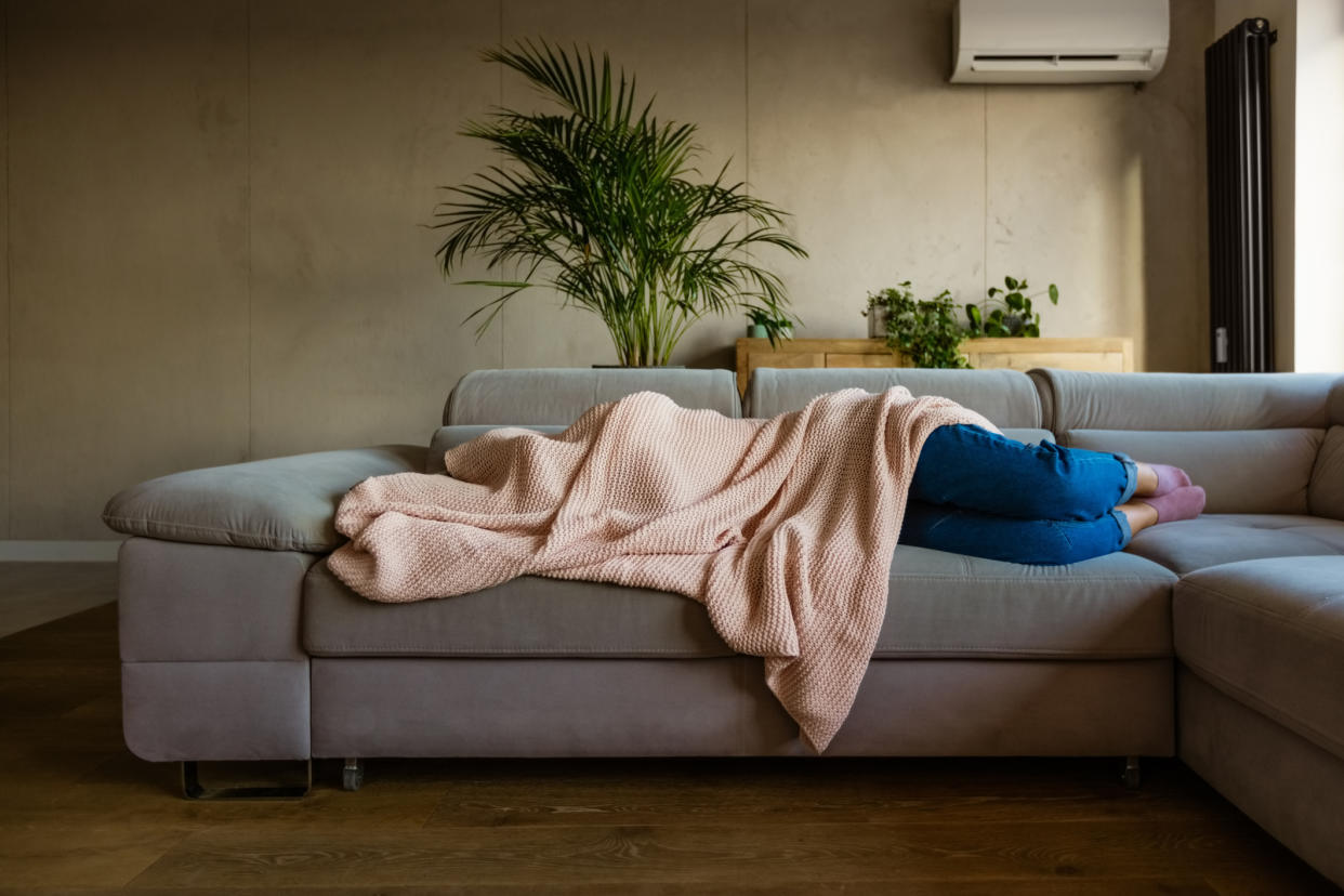 Woman on the sofa suffering with a hangover. (Getty Images)