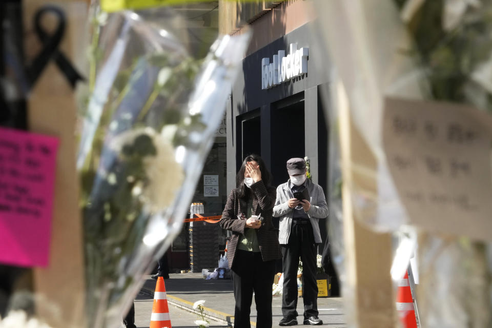 A woman weeps as she pays tribute to victims of a deadly accident during Saturday night's Halloween festivities, at a makeshift flower-laying area set up near the scene of the accident in Seoul, South Korea, Wednesday, Nov. 2, 2022. South Korean officials admitted responsibility and apologized on Tuesday for failures in preventing and responding to a Halloween crowd surge that killed more than 150 people and left citizens shocked and angry. (AP Photo/Ahn Young-joon)