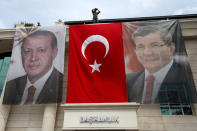 A special forces police officer takes security measures as he stands on top of a building where the portraits of Turkey's President Tayyip Erdogan (L), Prime Minister Ahmet Davutoglu and a Turkish flag are displayed in Istanbul, Turkey, June 3, 2015. REUTERS/Murad Sezer/File Photo