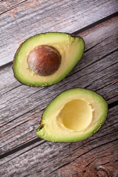 top view of cut avocado on wood background