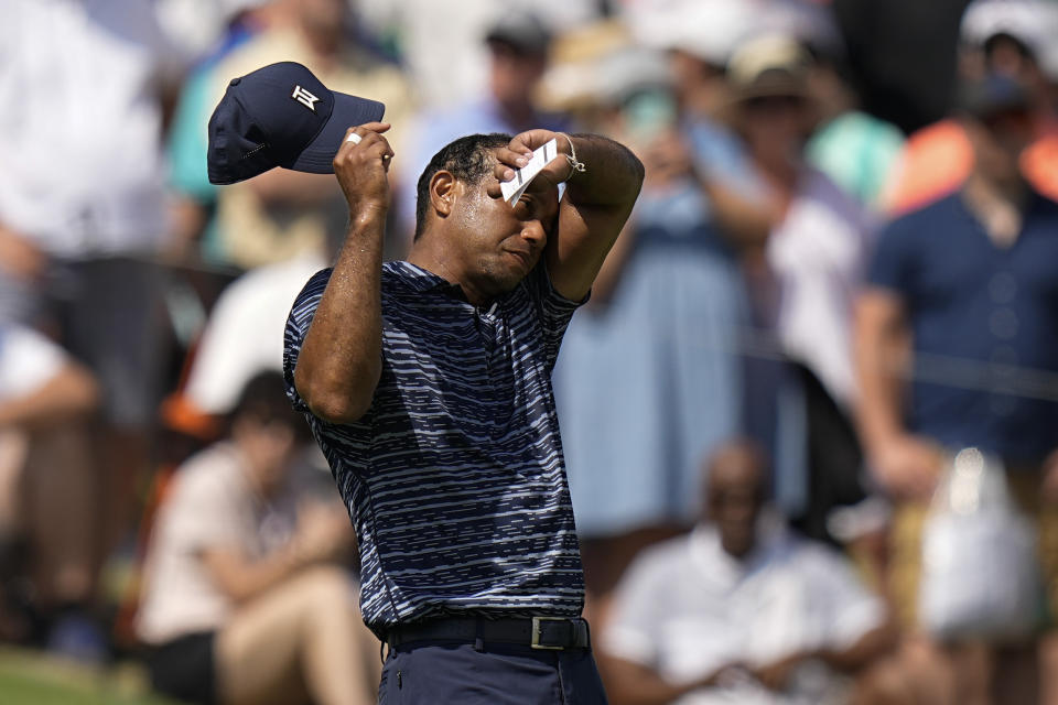 Tiger Woods wipes his face on the 18th hole during the first round of the PGA Championship golf tournament, Thursday, May 19, 2022, in Tulsa, Okla. (AP Photo/Eric Gay)