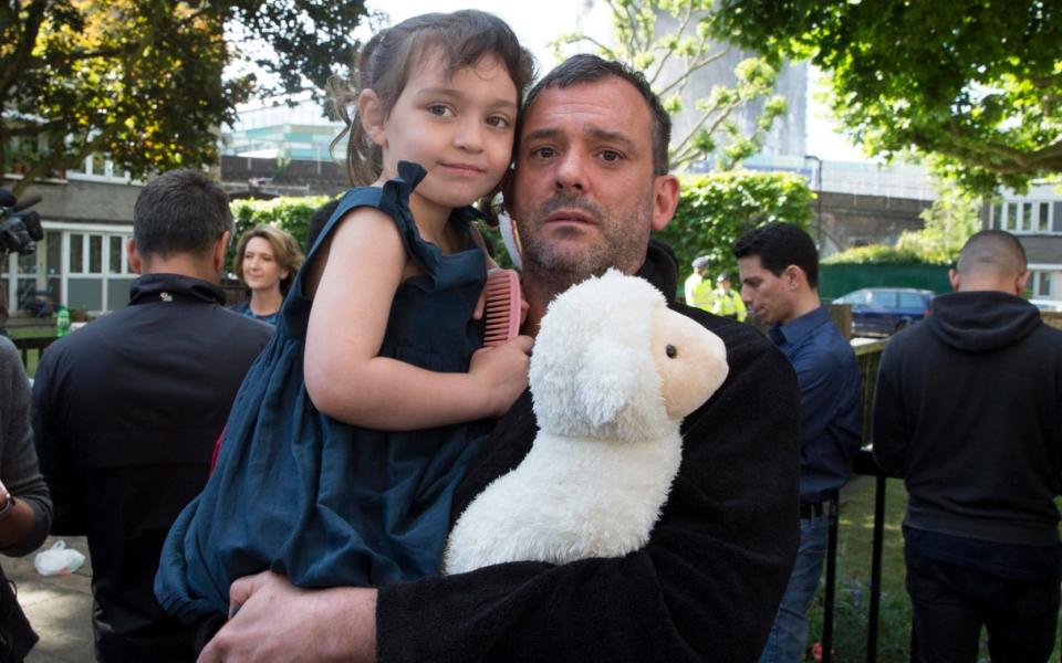 Michael Paramasivan with his step daughter Thea Kavanagh aged 5. They escaped form the 7th floor . - Credit: Heathcliff O'Malley for The Telegraph