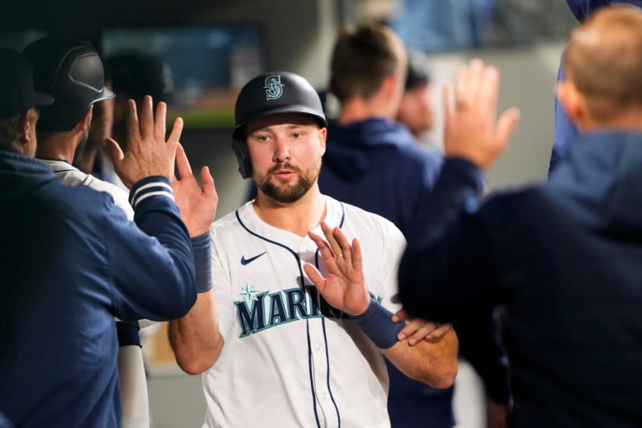 Seattle Mariners’ Cal Raleigh is greeted in the dugout after scoring on a bases-loaded walk of Luis Urías by Cleveland Guardians relief pitcher Nick Sandlin during the fourth inning of a baseball game Monday, April 1, 2024, in Seattle. (AP Photo/Lindsey Wasson)