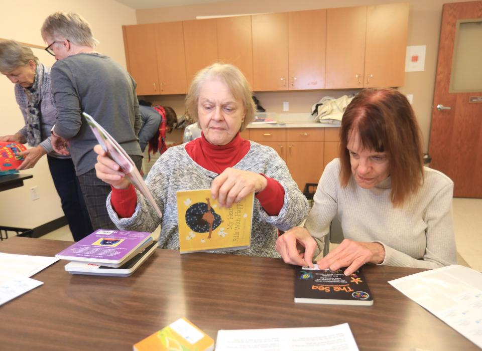 From left, Stephanie Pyrek an dGloria Ghedini, members of the Poughkeepsie Branch of the American Association of University Women label books for their Holiday Helping Hand project, Leading to Reading at the United Methodist Church in Hude Park on November 29, 2023.