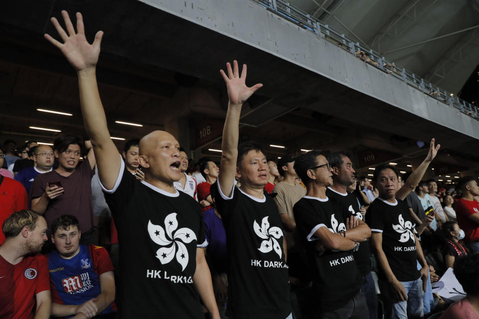 Hong Kong soccer fans wear T-shirt featuring black version of the Hong Kong flags to protest against government during the FIFA World Cup Qatar 2022 and AFC Asian Cup 2023 Preliminary Joint Qualification Round 2 soccer match between Hong Kong and Iran, in Hong Kong, Tuesday, Sept. 10, 2019. The crowd broke out into "Glory to Hong Kong," a song reflecting their campaign for more democratic freedoms in the semi-autonomous Chinese territory. (AP Photo/Kin Cheung)