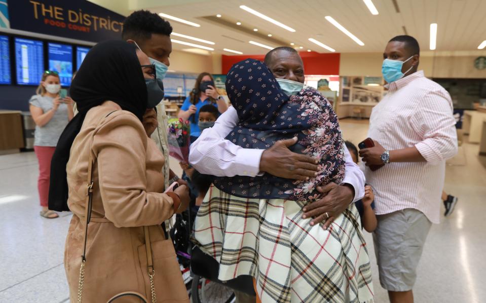 Mohamed Salem Ali gets a hug from wife Fadumo Hussien shortly after he arrived at John Glenn International Airport on April 8, 2021. Ali, a Somali man living in Malaysia, wasn't able to come for three years to join his family in Columbus due to Trump's Muslim ban. When Biden lifted the ban earlier this year, the family got their father a visa and he arrived in Columbus Thursday morning, April 8, 2021.