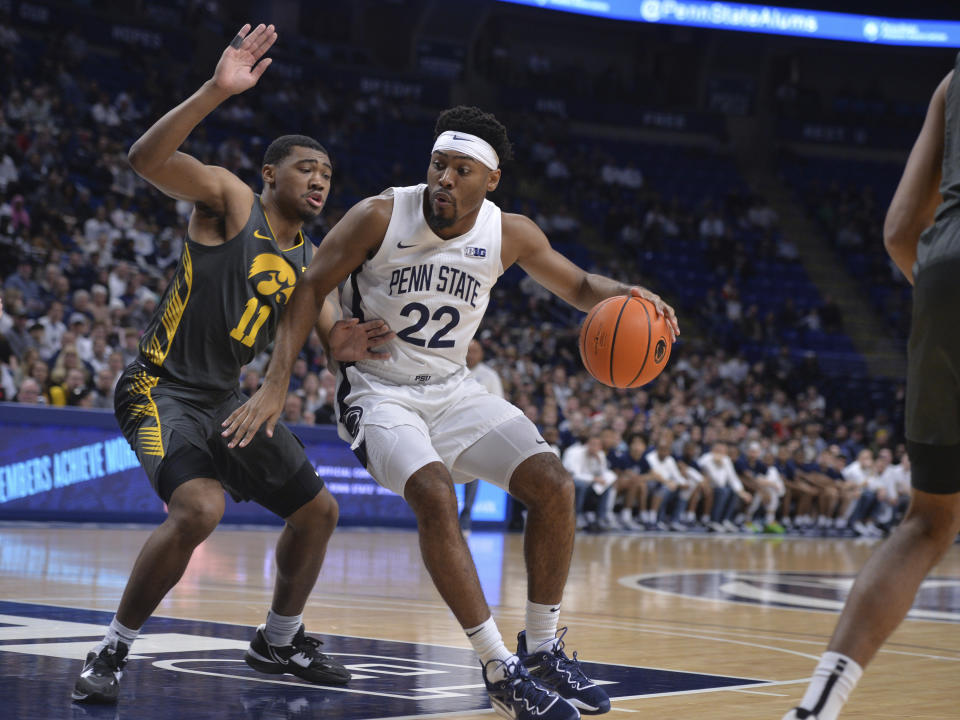 Penn State's Jalen Pickett (22) moves to the basket on Iowa's Tony Perkins (11) during the first half of an NCAA college basketball game, Sunday, Jan. 1, 2023, in State College, Pa. (AP Photo/Gary M. Baranec)