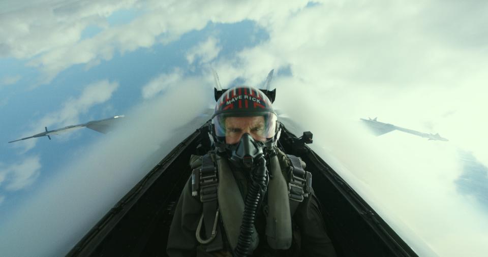 Tom Cruise with a helmet and mask on inside a fighter jet