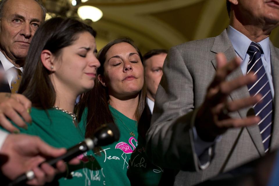 Relatives of the victims of the Sandy Hook shooting listen to Sen. Joe Manchin speak