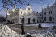 A monk and a woman walk inside the Pechersk Lavra monastic complex in Kyiv, Ukraine, Thursday, Dec. 1, 2022. Ukraine on Friday banned the activities of religious organizations "affiliated with centers of influence" in Russia and said it would examine the links between the Ukrainian and Russian Orthodox churches. (AP Photo/Bernat Armangue)