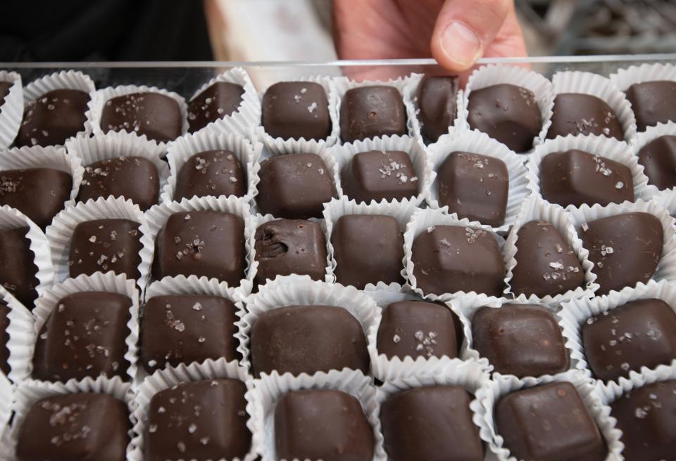 Candy maker Scott Ghelfi holds a tray of the popular dark chocolate sea salt caramels on Tuesday at his store, Ghelfi's Candies of Cape Cod, on Main Street in Falmouth.