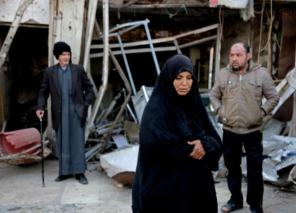 Civilians inspect the site of a car bomb attack in the eastern Ur neighborhood of Baghdad, Iraq, Tuesday, Feb. 18, 2014. A wave of explosions rocked mainly Shiite neighborhoods in Baghdad shortly after sunset on Monday, killing and wounding scores of people, said Iraqi officials. (AP Photo/Karim Kadim)