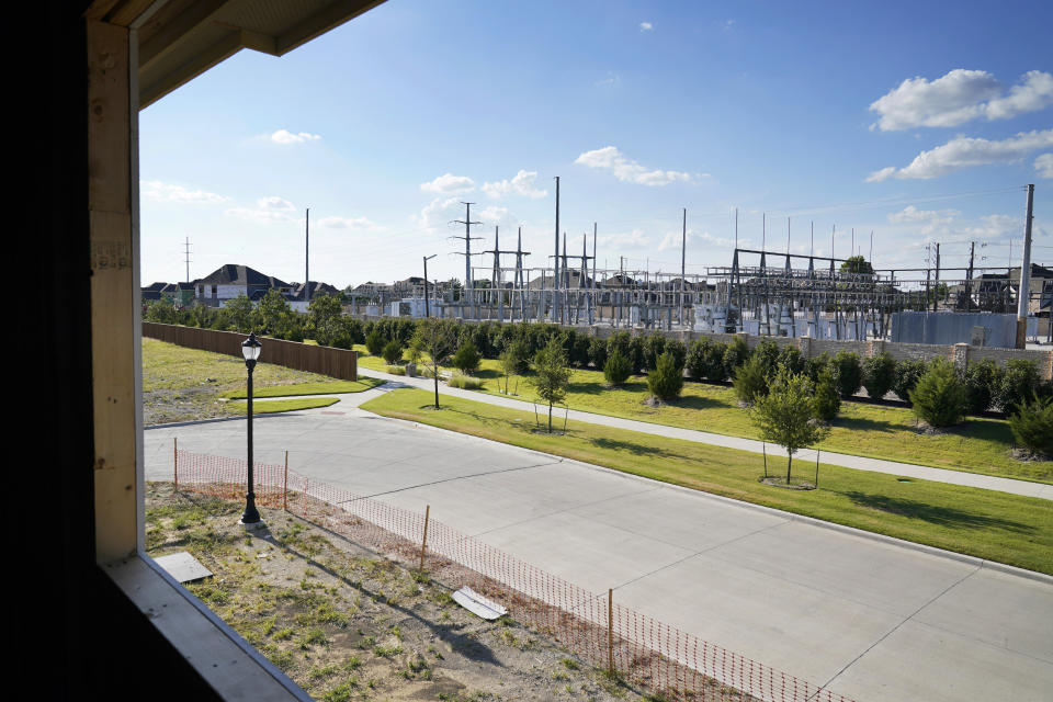 A electrical power grid, right rear, is seen outside the window and across the street of a home under construction in a new subdivision in Frisco, Texas, Thursday, Aug. 12, 2021. The once-a-decade battle over redistricting is set to be a showdown over the suburbs, as new census data released Thursday showed rapid growth around the some of the nation's largest cities and shrinking population in many rural counties. (AP Photo/Tony Gutierrez)