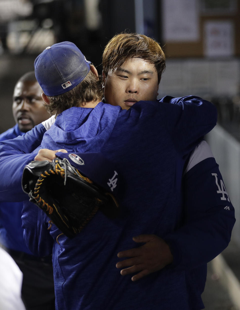 Los Angeles Dodgers pitcher Hyun-Jin Ryu, right, of South Korea, is hugged by pitcher Clayton Kershaw in the dugout after the seventh inning of Game 1 of the National League Division Series against the Atlanta Braves on Thursday, Oct. 4, 2018, in Los Angeles. The Dodgers won 6-0. (AP Photo/Jae C. Hong)