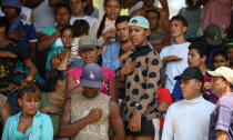 <p>Central American migrants from Honduras sing their national anthem during the annual Migrant Stations of the Cross caravan or “Via crucis,” organized by the “Pueblo Sin Fronteras” activist group, as the group makes a few-days stop in Matias Romero, Oaxaca state, Mexico, Monday, April 2, 2018. (Photo: Felix Marquez/AP) </p>