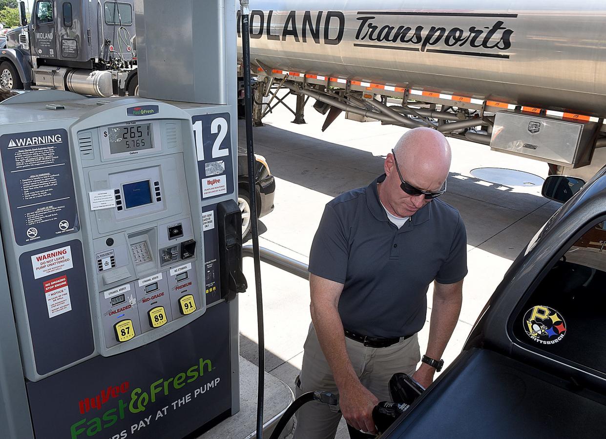 Brian Grove fills the gas tank on his pickup truck last month in Columbia as a gasoline transport truck pulls into a Hy-Vee gas station on Conley Road.